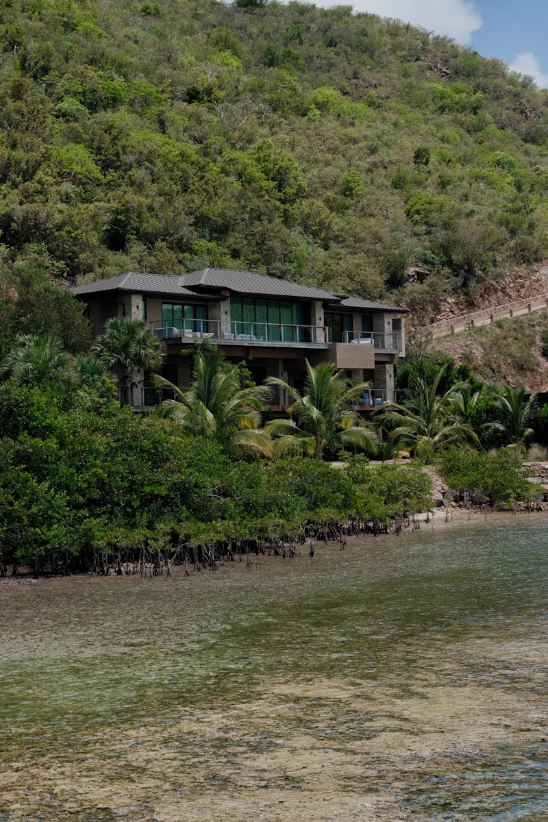 a house sitting on the side of a lush green hillside
